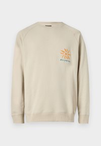 Beige Sweatshirt aus weichem Material; verfügt über Raglanärmel und ein kleines orangefarbenes Sonnenlogo auf der linken Brust mit blauer Schrift.