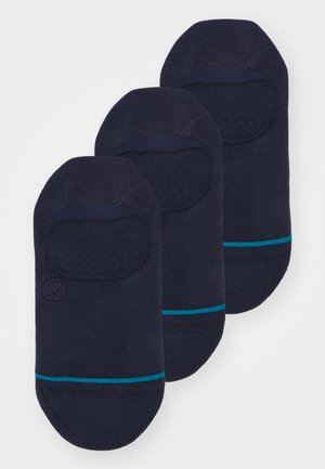 Sötétkék bokassockok textúrált felső pánttal és türkiz csíkokkal. Puha kötött anyag, alacsony szabás és kör alakú logó az egyik zoknin.