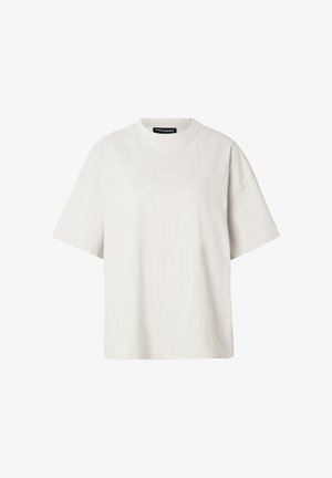 Lichtbeige oversized T-shirt met korte mouwen, ronde halslijn en een klein wit logotekstje centraal bij de borst.