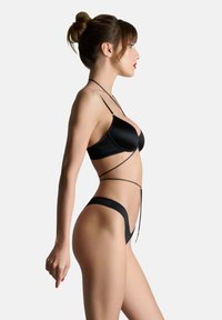 Schwarzes Bikini aus glattem Stoff, mit einem minimalistischen Design, dünnen Trägern und einer hochgeschnittenen Silhouette. Zarte goldene Akzente.