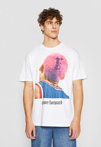 Hvit bomulls t-skjorte med et fargerikt grafisk motiv av en person med rosa krøllete hår, tekst "power forward" i svart under designet.