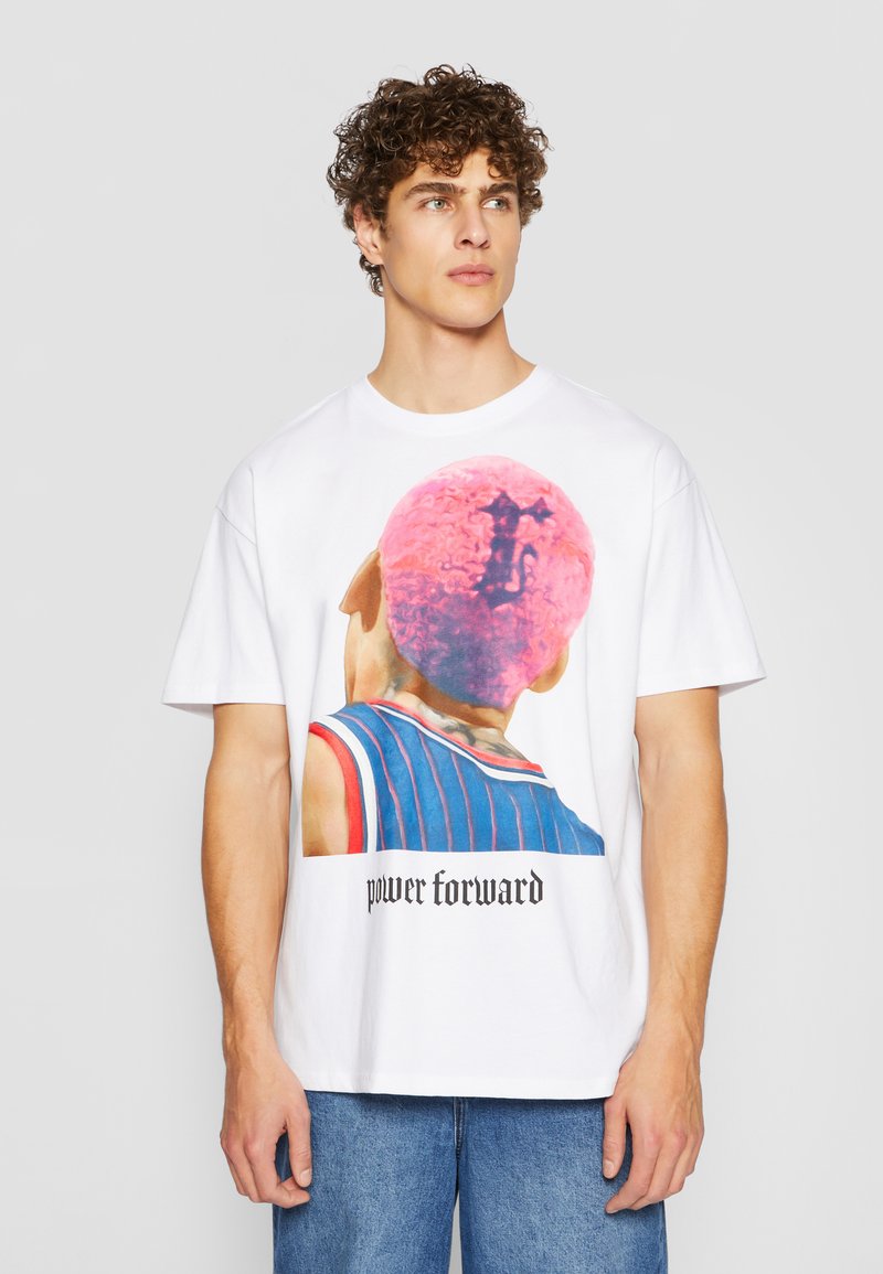 Hvit bomulls t-skjorte med et fargerikt grafisk motiv av en person med rosa krøllete hår, tekst "power forward" i svart under designet.