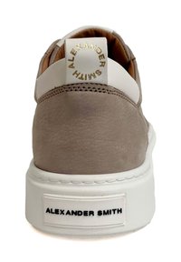 Sneaker in pelle color marrone chiaro con dettagli bianchi. Presenta un collare imbottito, il logo sul tallone e una spessa soletta bianca. Texture liscia.