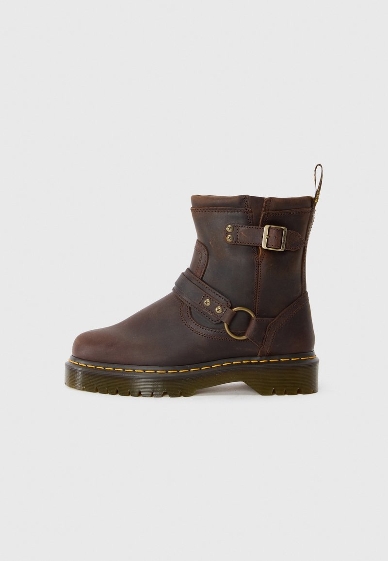 Bottine en cuir marron avec détails cousus, accent de boucle et bout rond. Dispose d'une semelle texturée avec une couture contrastante jaune.