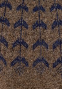 Tkanina wełniana z brązowym tłem i granatowymi wzorami w kształcie strzałek, z teksturowanym, puszystym wykończeniem na całej powierzchni.