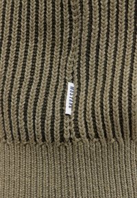 Gestrickte Mütze in Olivgrün und Schwarz, mit dicken horizontalen Streifen. An der Seite ist ein kleines weißes Etikett mit der Aufschrift "MUSTANG" sichtbar.