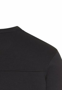Zwarte t-shirt met een ronde hals, korte mouwen en een textuurstof. Inclusief een horizontale naaddetail over de rug.