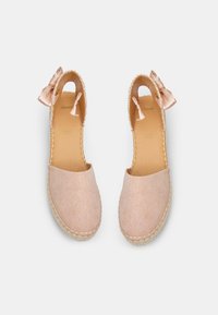 Gai rozā espadrilles ar lina tekstūru, atvērtām malām un satīna loku akcentu. Aprīkotas ar austas jūtas zoli un gludu, brūnu iekšzoli.