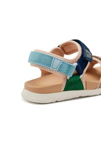 Sandale multicolore avec une semelle en caoutchouc, des sangles en tissu bleu, vert et marine, dotée de fermetures ajustables et d'une semelle intérieure texturée.