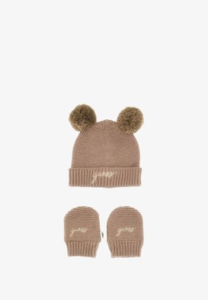Berretto lavorato a maglia color beige con due pompon sulla parte superiore, caratterizzato da un risvolto a coste e logo "guess" ricamato. Paio di guanti senza dita abbinati sotto.