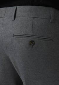 Szare, dopasowane spodnie z gładką teksturą, tylną kieszenią ozdobioną kontrastowym guzikiem oraz precyzyjnie wykonanymi przeszyciami.