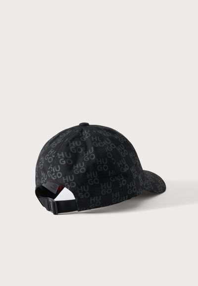 Casquette de baseball noire réglable avec motif répétitif du logo "HUGO" en gris foncé, vue de dos sur fond blanc.