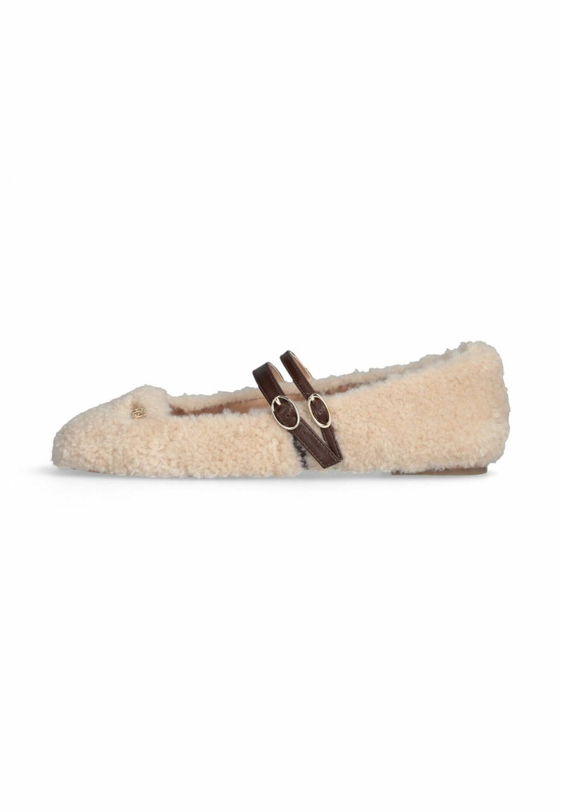 Beige, pluizige platte schoen met twee donkerbruine, verstelbare gespbandjes over de bovenkant en een klein gouden embleem nabij de tenen.