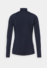 Námořnicky modrý sportovní top s dlouhými rukávy, vysokým límcem a bílými bočními pruhy, vyrobený z lehké a hladké látky s přiléhavým střihem.