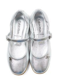 Para srebrnych metalicznych butów Mary Jane z paskami na sprzączki, logo Calvin Klein na noskach oraz napisem "Made in Italy" na wkładkach.