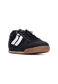 Zapatillas deportivas negras de diseño bajo, con dos rayas blancas, parte superior texturizada negra y suela de goma.