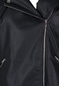 Veste en simili cuir noir avec un col cranté, des fermetures éclair argentées et des poches latérales zippées. Texture lisse avec des coutures ajoutant de la structure.