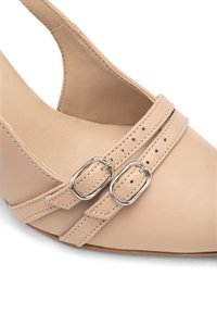 Scarpa con tacco alto in pelle beige con punta affusolata, caratterizzata da due cinturini decorativi e fibbie in argento per un tocco di classe.