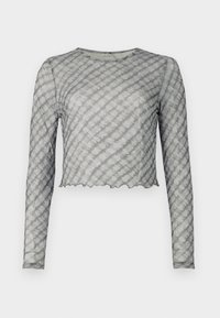 Dolga majica s kratkimi rokavi, iz prosojnega sivega materiala z svetlimi diagonalnimi črtami. Ima okroglo izrez in valovit rob. Mehak material, prilegajoč kroj.