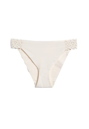 Bañador de color beige claro con una cinturilla plana adornada con encaje. Tejido suave con un diseño sin costuras, con un corte clásico de braguita y bordes elásticos.
