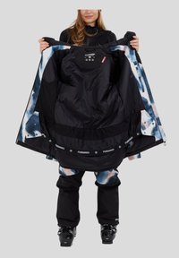 Czarna kurtka narciarska z kolorowym abstrakcyjnym wnętrzem, z wysokim kołnierzem, zamkiem błyskawicznym, elastycznymi mankietami i logowaniem wzdłuż dolnego brzegu.