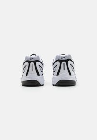 Nike tenisice s bijelim i crnim mrežastim gornjim dijelom, podstavljenim ovratnikom, teksturiranim potplatom i istaknutim AIR brendingom na peti.
