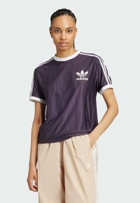 Paarse Adidas T-shirt met verticale krijtstrepen, een witte kraag en drie witte strepen aan de zijkant. Voorzien van een wit logo in het midden van de borst.