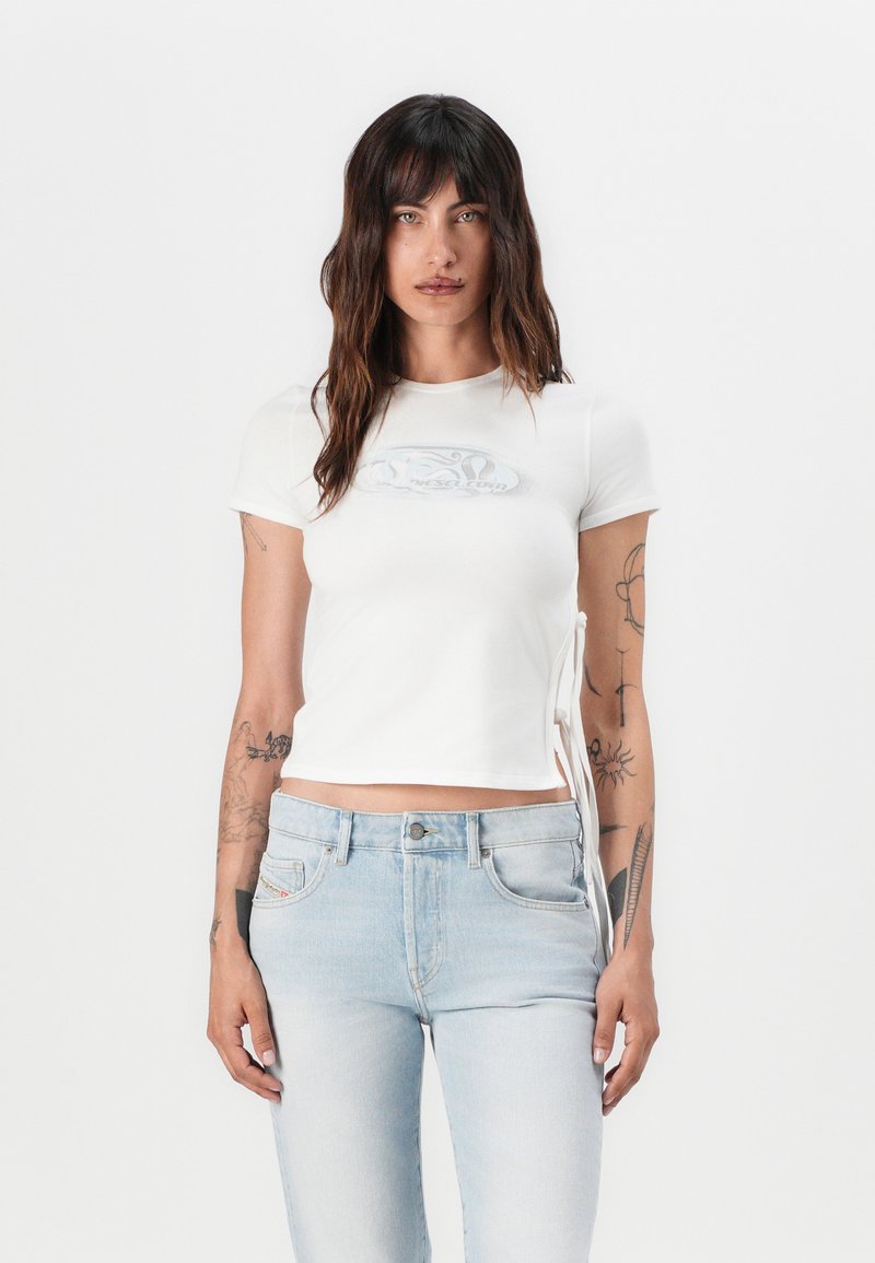 White cropped t-shirt with a round neckline and short sleeves. Features side ties and a faint graphic logo on the chest. Textured cotton fabric.