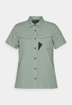 Short-sleeve, button-up shirt in light green fabric with two chest pockets, black buttons, and a logo with a blue accent and a triangular design.