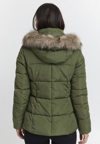 Olivengrøn pufferjakke med hætte og betræk af kunstpels, der har en quiltet design og elastiske manchetter. Viser bagsiden med en afslappet pasform.