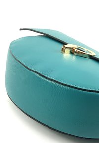 Türkisfarbene Lederhandtasche mit glatter Oberfläche, ovaler Form und schwarzen Nähten, ausgestattet mit einem goldenen Metallverschluss an einem Klappenverschluss.