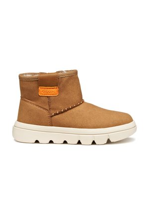 Bottes de cheville en daim marron avec une semelle en caoutchouc blanc, présentant un accent orange à l'arrière et une couture décorative sur le côté.