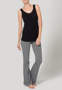 Black tank top with lace trim and gray flared sweatpants, made from soft, stretchy fabric, featuring a fitted silhouette and casual design.