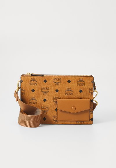 Tan leather crossbody bag featuring embossed MCM logos, a front pocket with a snap closure, and a woven strap. Gold hardware accents.
