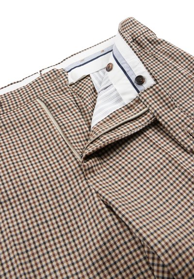 Bruin en crème geblokte stof met een gladde textuur, voorzien van een gestreepte binnenvoering en twee bruine knopen bij de taille.