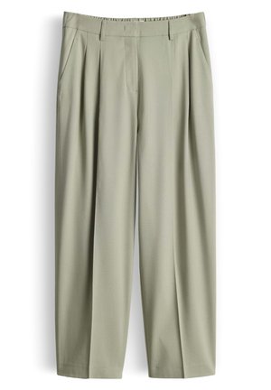 Pantalon taille haute beige clair avec plis, poches latérales, passants pour ceinture et fermeture éclair devant.