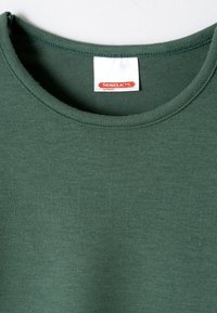 T-shirt in cotone verde scuro con colletto rotondo, presenta una texture liscia e un piccolo etichetta bianca con testo rosso all'interno del colletto.