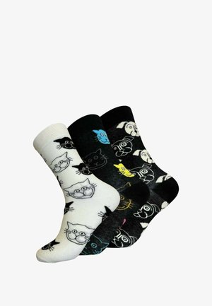 Tre par sokker: en hvid med sorte katteansigt, en sort med farverige accenter, og en anden sort med katte- og hundeansigt i forskellige farver.