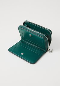 Teal leather wallet with silver zipper, interior card slots, and snap closure. Smooth texture and compact design for easy carry.
