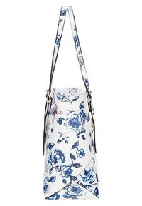 Valkoinen olkalaukku sinisellä ja purppuranvärisellä kukkakuviolla sekä pitkä säätöremmi, kuvattu sivulta, jossa on taitettava alareuna.