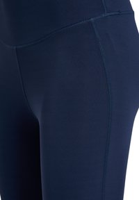 Leggings blu navy realizzati in un tessuto liscio e stretch. Presentano una cintura alta e cuciture flatlock per comfort e durabilità.