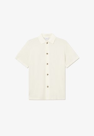 Chemise en maille blanche à manches courtes avec un col pointu et six boutons marron sur le devant.