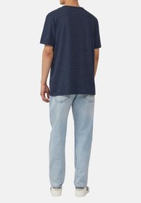 Marineblauwe katoenen T-shirt met een relaxed fit, voorzien van korte mouwen en een ronde kraag, gecombineerd met lichtblauwe denim jeans.