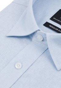 Jasnoniebieska, bawełniana koszula z kołnierzykiem w szpic, z białymi guzikami i metką o regularnym fasonie. Gładka faktura, minimalny wzór.