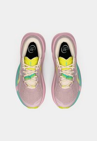 Ténis atléticos leves com parte superior em rede cor-de-rosa, detalhes em amarelo, painel lateral turquesa e atacadores brancos. Design de biqueira redonda.