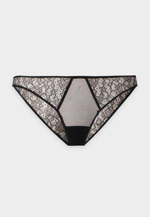 Sous-vêtement style bikini en dentelle noire avec motif floral et panneau en maille transparente à l'avant sur un fond clair uni.