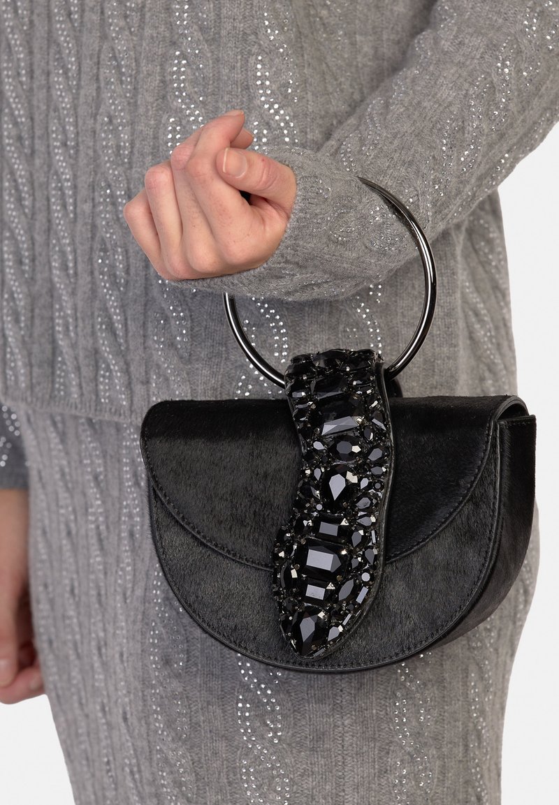 Piccola borsa nera con finitura strutturata, caratterizzata da una tracolla decorativa in cristallo e da una maniglia circolare in metallo.