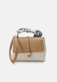 Sac à main avec un corps en cuir beige et une section inférieure crème. Il dispose d'une anse tressée en tissu bleu et à motifs, ainsi que d'un fermoir doré.