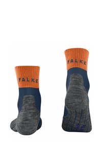 Calze di colore blu navy con polsini a righe arancioni, caratterizzate dal marchio "FALKE". Suole grigie chiare visibili, che evidenziano la consistenza e i dettagli del design.