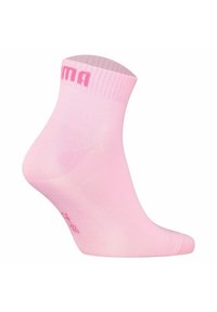 Calzino rosa alla caviglia con una finitura a coste, caratterizzato da una superficie liscia e un marchio discreto di colore contrastante vicino alla caviglia.